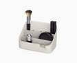 Joseph Joseph Viva tiered cosmetic organiser in shell, holding make-up brushes.