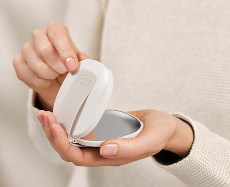 The compact opened out to show both the standard and the magnifying mirror.