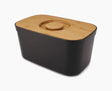 Joseph Joseph black bread bin with its bamboo lid in place, front view.