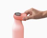 The Loop bottle carried by its loop for hands-free transport.
