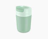 Joseph Joseph Sipp travel mug in green with the flip-top lid closed.