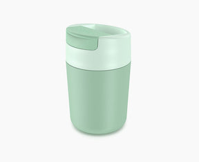 Joseph Joseph Sipp travel mug in green with the flip-top lid closed.
