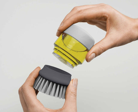 The brush held in the palm while scrubbing a pan.