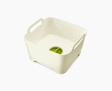Joseph Joseph Wash and Drain washing-up bowl in white and green, shown from above.