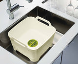 The white and green bowl lifted by its large side carry handles.