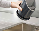 The integrated draining saucer and its pouring spout underneath.