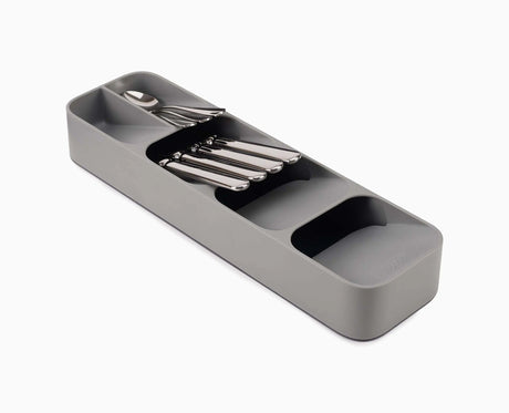 Joseph Joseph DrawerStore compact cutlery organiser in grey, shown filled with a full set of cutlery.