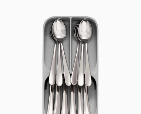 The tray sitting inside an open kitchen drawer with cutlery sorted into its tiers.