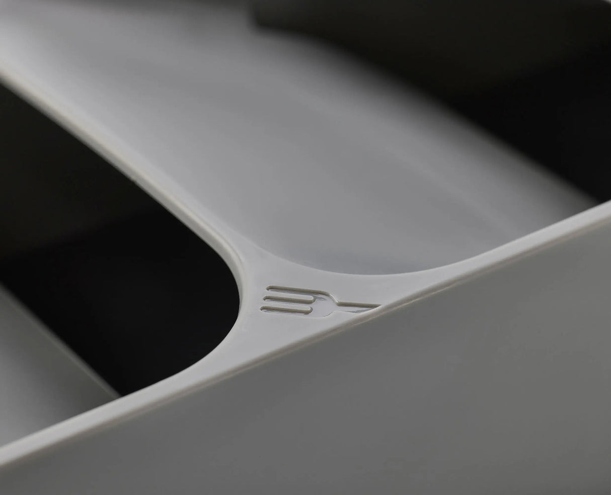 A hand lifting a fork from the top tier of the grey cutlery organiser.