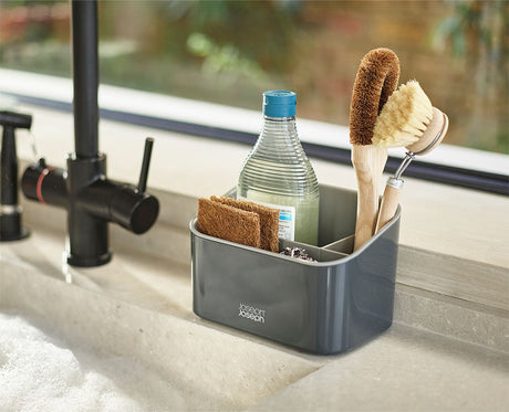 The caddy open, showing a washing-up liquid bottle, dish brush and sponges in their sections.
