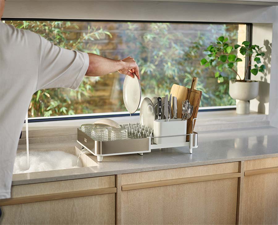 Joseph Joseph Extend Steel dish rack extended to twice its size and loaded with plates
