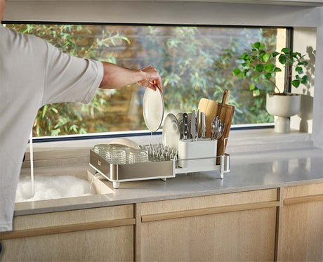 Joseph Joseph Extend Steel dish rack extended to twice its size and loaded with plates