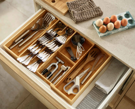 Overhead view of the five overlapping cutlery compartments with their identification icons.