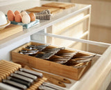 Close-up of the icons marking each cutlery compartment on the bamboo tray.