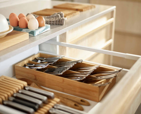 Close-up of the icons marking each cutlery compartment on the bamboo tray.