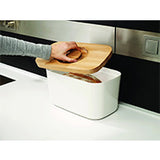 Angled view of the white Joseph Joseph melamine bread bin and its beech wood lid.