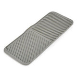 Joseph Joseph Duo foldable draining mat in grey, laid out flat.