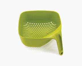Joseph Joseph square colander in green seen from the front with its tall vertical handle