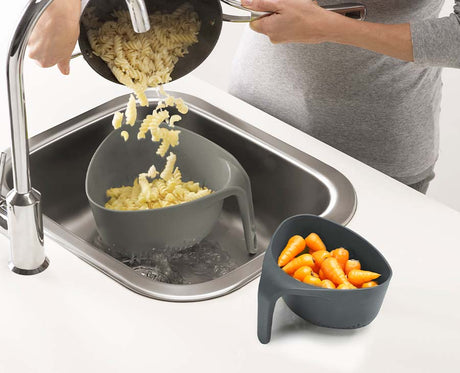 The two grey colanders separated side by side to show the large and small sizes
