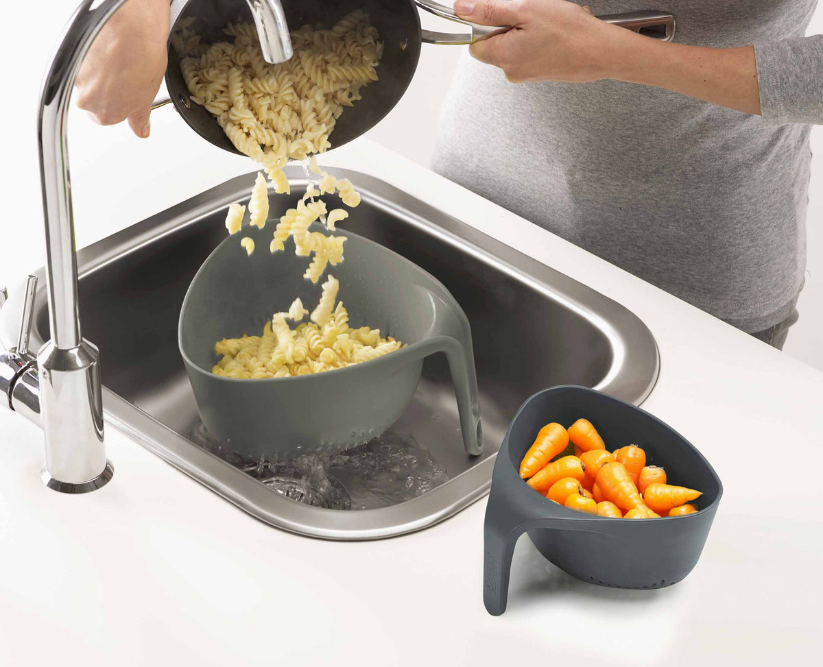 Close-up of the vertical handle on a grey Nest colander