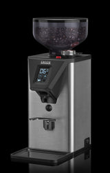 Gaggia MDF 55 coffee grinder angled view with ground coffee, dark background