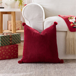 Christmas cushion cover 45x45cm, red corduroy with pom pom corners, on a white armchair