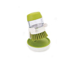 Side profile of the green Palm Scrub brush showing its soap reservoir body.