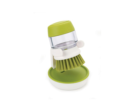 Side profile of the green Palm Scrub brush showing its soap reservoir body.