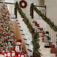 Pre-decorated green Christmas garland with built in lights, pine cones and red berries, 2.7m, on a staircase