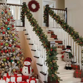 Pre-decorated green Christmas garland with built in lights, pine cones and red berries, 2.7m, on a staircase